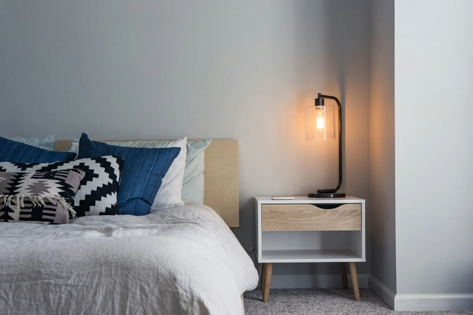Guest bedroom with a wooden bedside table and lamp